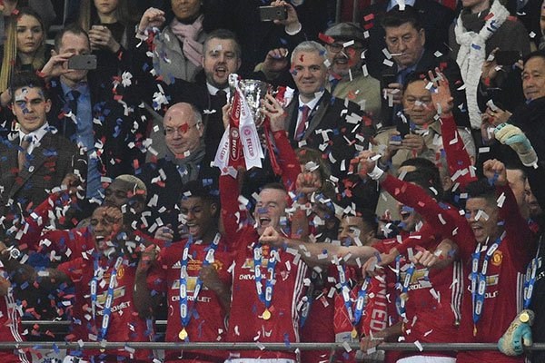 Manchester United's English striker Wayne Rooney lifts the trophy as Manchester United players celebrate their victory after the English League Cup final football match against Southampton at Wembley stadium in north London on February 26, 2017. Manchester United won the game 3-2. PHOTO | GLYN KIRK |  AFP